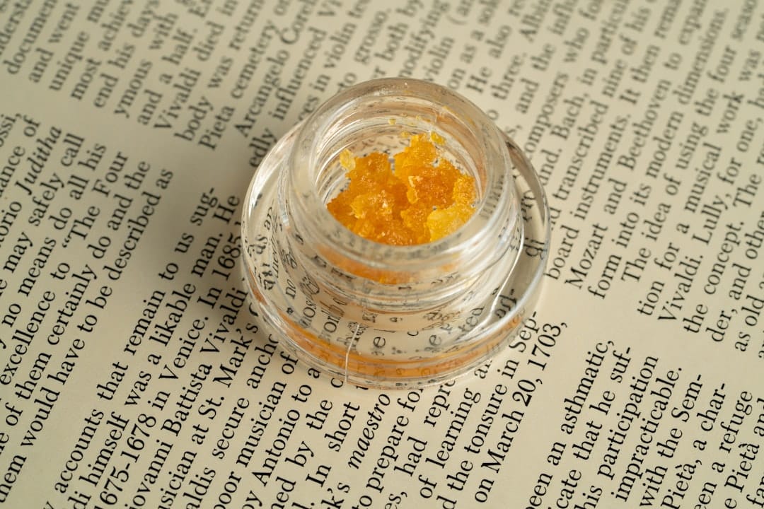 Golden cannabis concentrate in a small glass jar showing the rich amber colour of quality extract