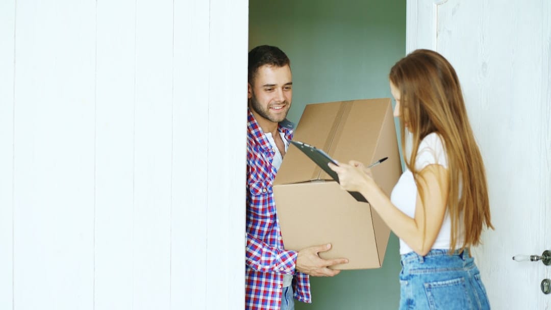Couple receiving a cannabis delivery package at their front door