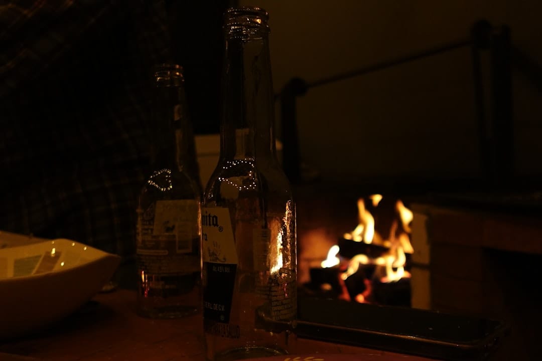 Cozy evening relaxation scene with bottles by a warm fireplace