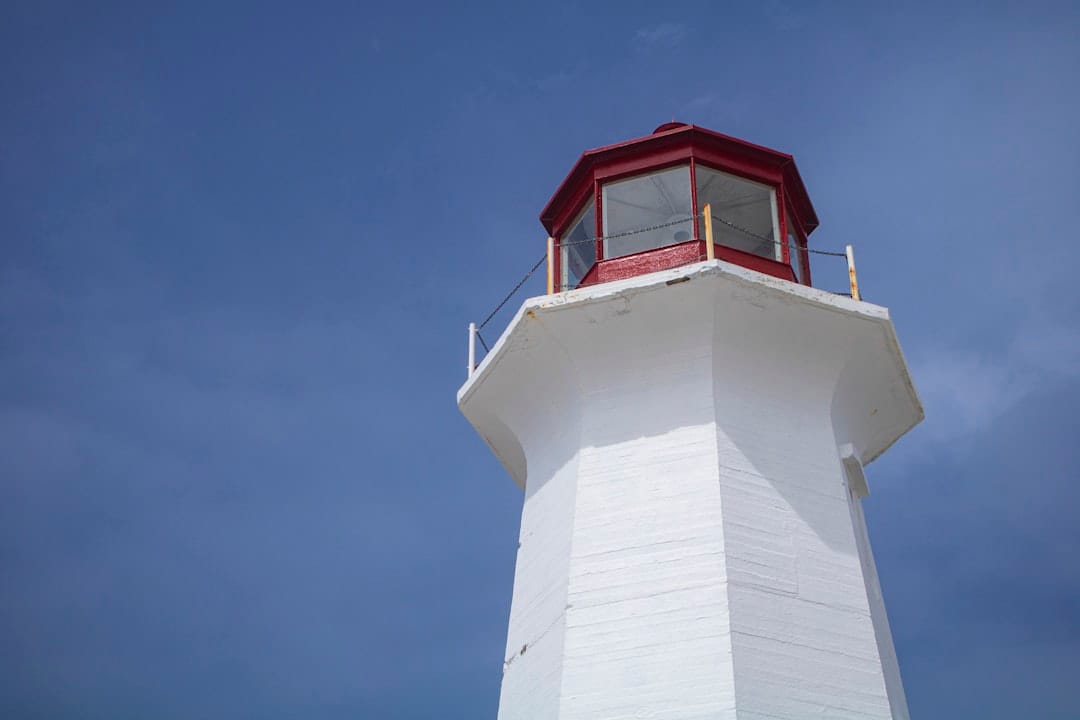 Peggy's Cove lighthouse on the Nova Scotia coast with blue sky