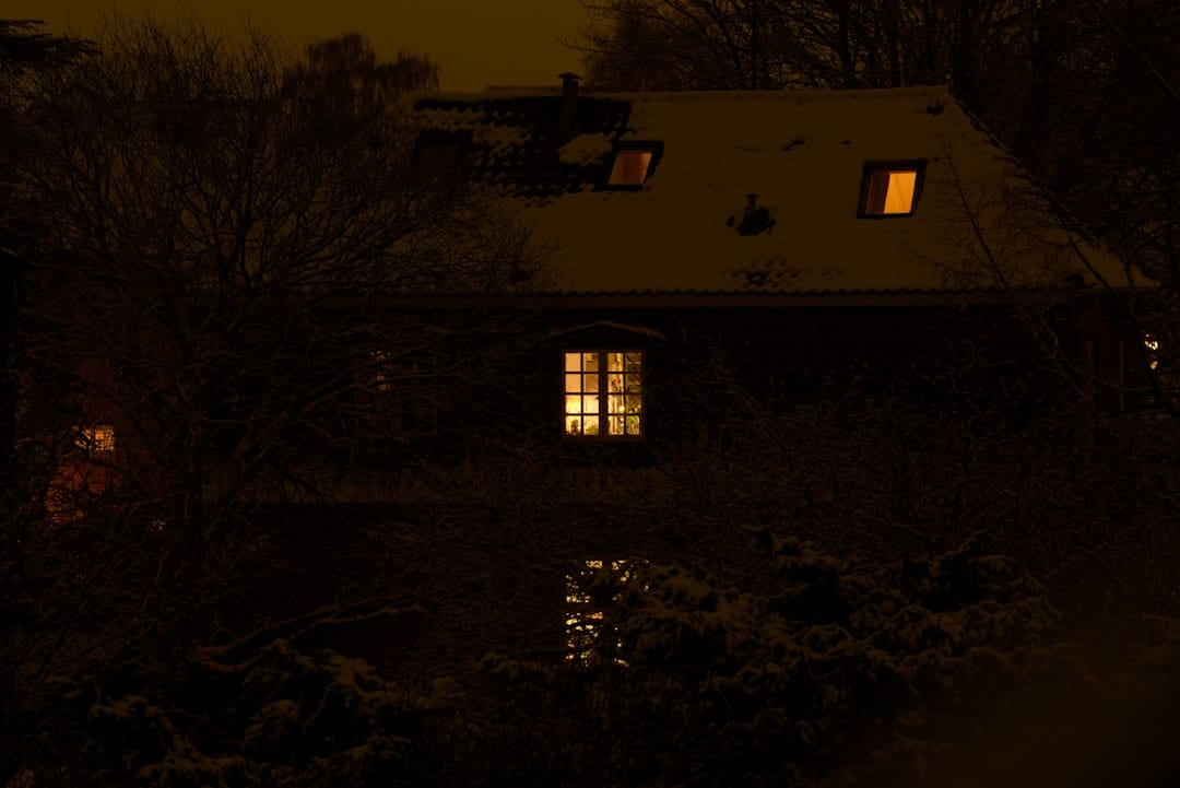 Warm cozy home with illuminated windows on a cold winter evening perfect for relaxing with cannabis