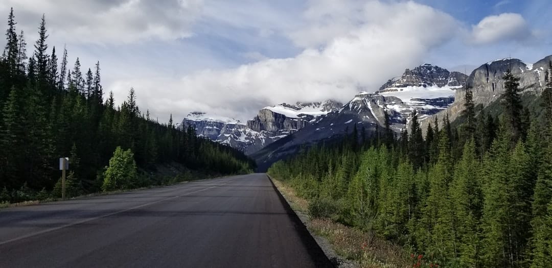 Scenic road through Banff National Park with Rocky Mountain peaks in the background