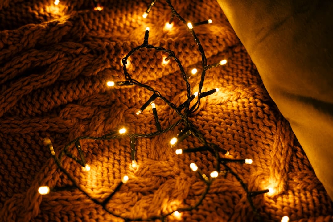 Warm fairy lights draped on a textured blanket representing cozy evening cannabis relaxation