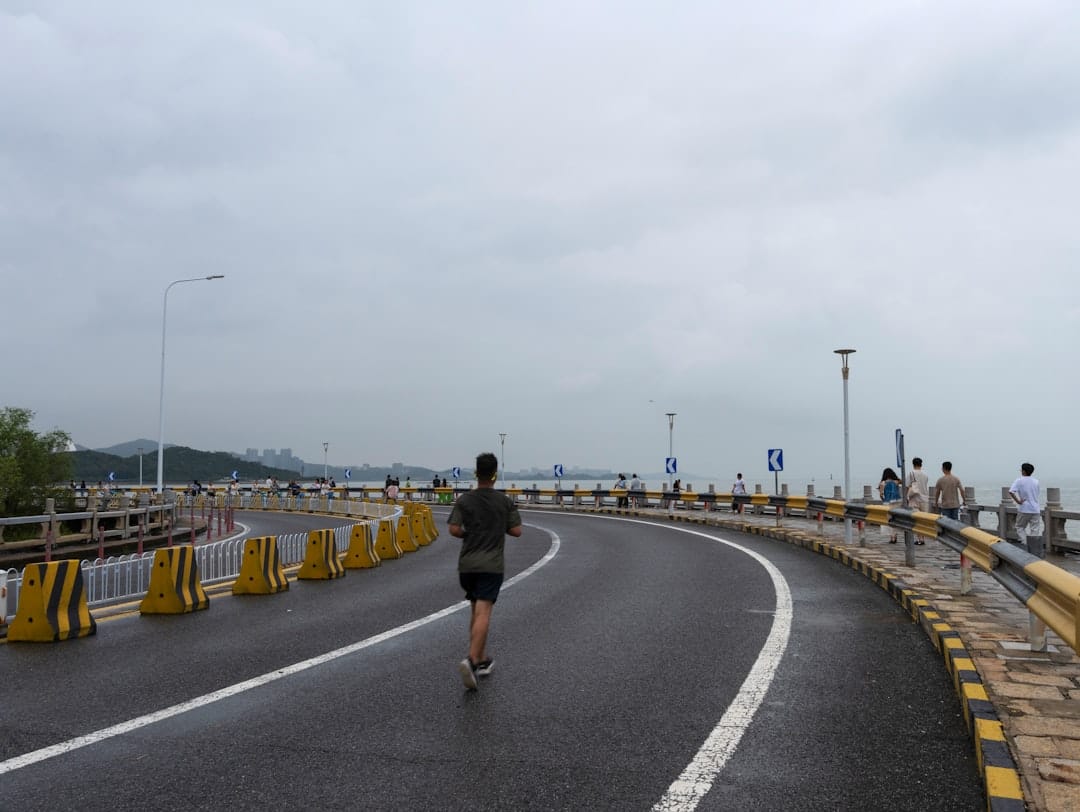 Person jogging along an ocean road as exercise during a cannabis tolerance break