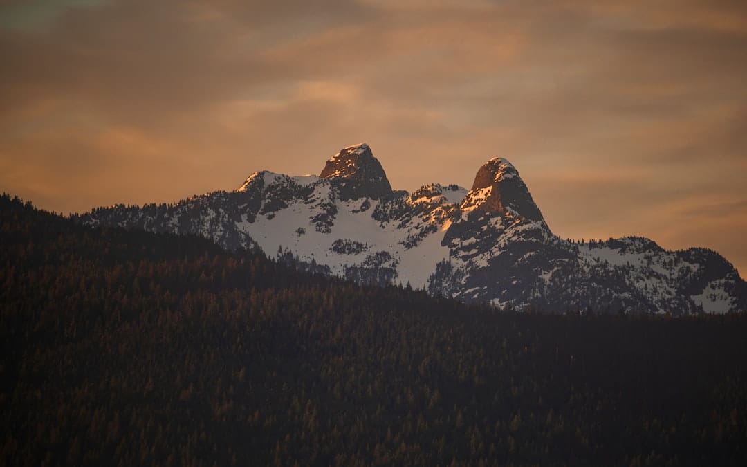 Snow-capped British Columbia mountains illuminated by golden sunset light