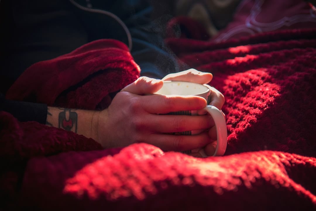 Person holding a warm cup on a cozy winter evening perfect for unwinding with cannabis