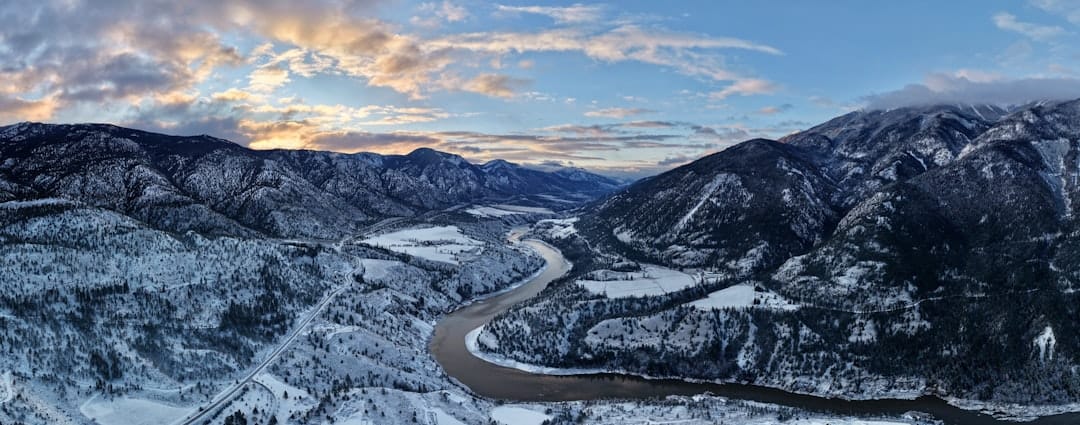 Snow covered mountain valley with river winding through BC winter landscape