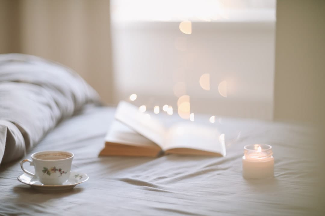 Cozy evening relaxation scene with coffee and book on bed perfect for indica cannabis wind-down