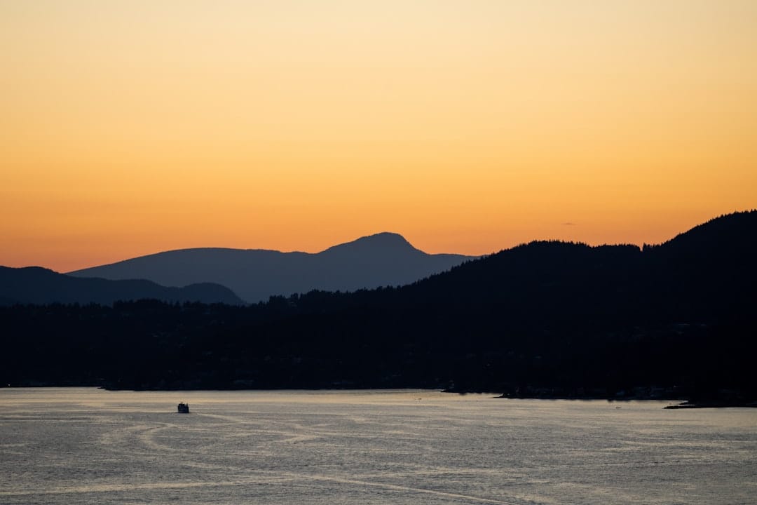Vancouver harbour with mountains in the background and calm water reflecting the BC coastline