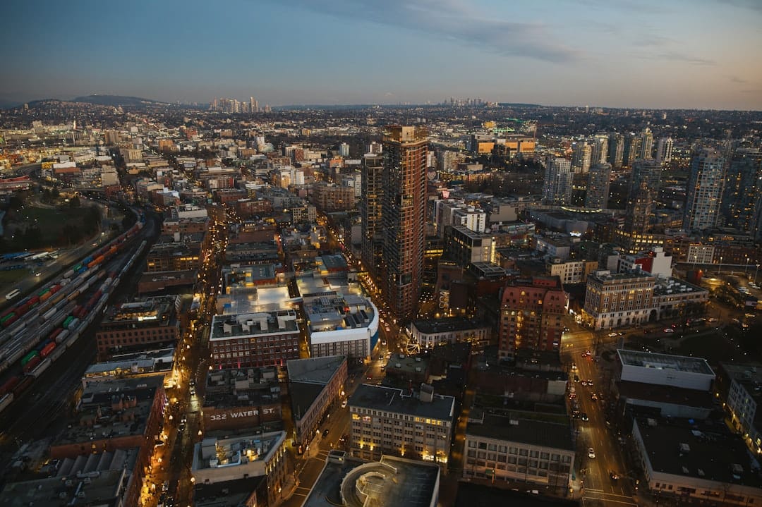 Aerial view of downtown Vancouver skyline at dusk with mountains in background