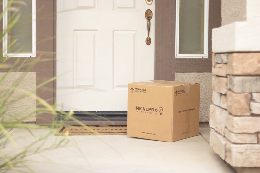 Brown cardboard delivery package at front door of residential home