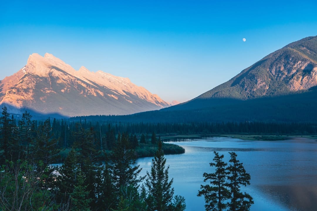 Serene mountain lake at dusk with mountain reflections reminiscent of Kootenay Lake near Nelson BC