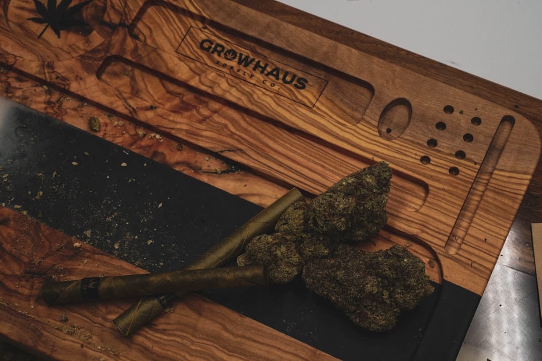 Ground cannabis on a wooden rolling tray with rolling supplies