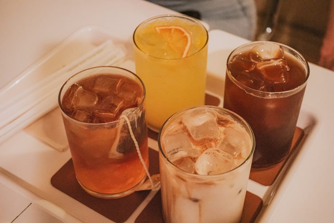 Four different iced THC drinks and cannabis beverages lined up on a table