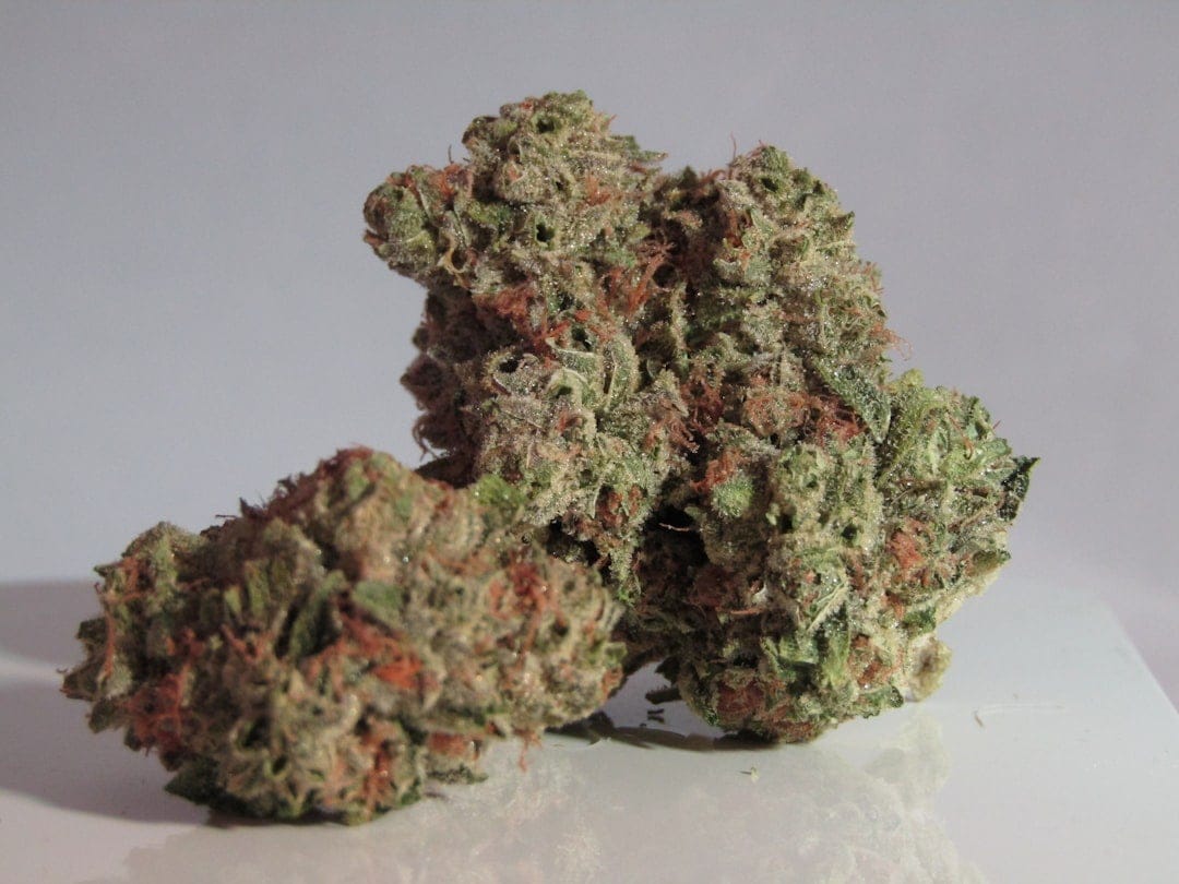 Dense cannabis kush buds with frosty trichomes and green hues
