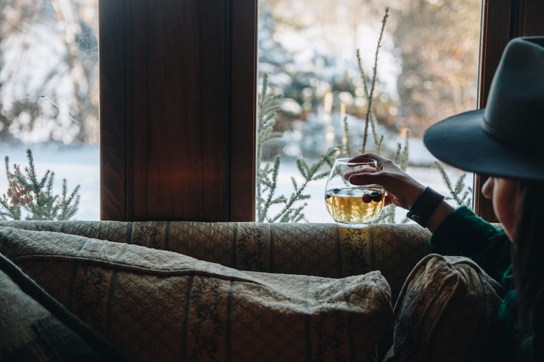 Woman relaxing on a cozy sofa by a window enjoying a calm evening at home