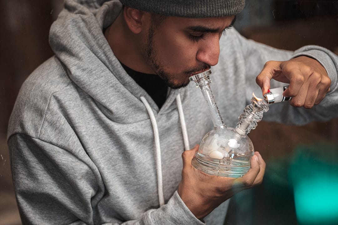 Person using a glass pipe to consume cannabis concentrates demonstrating a popular consumption method