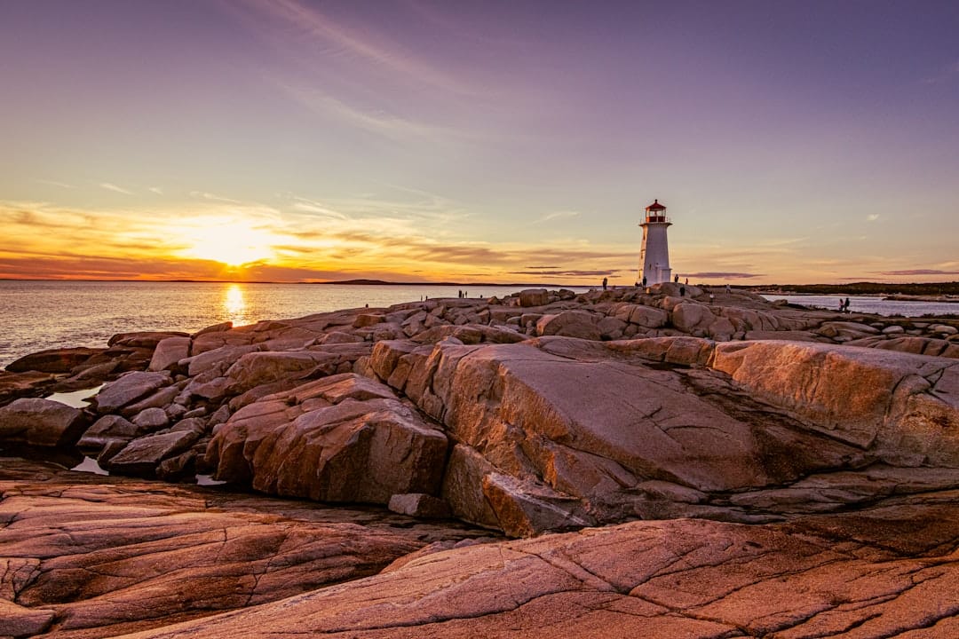 Lighthouse on rocky Nova Scotia coastline with ocean waves