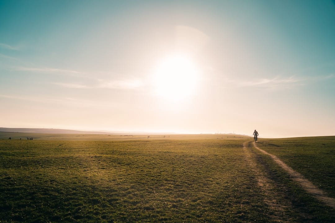Person walking peacefully through green field representing microdosing benefits