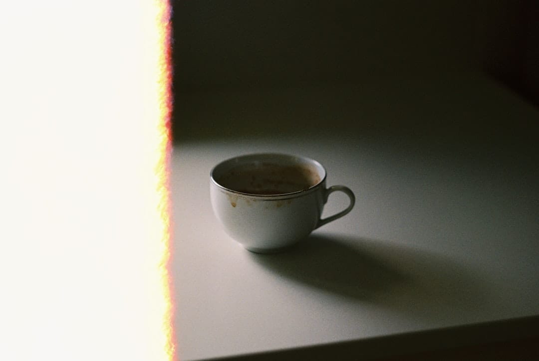 White ceramic teacup on a table in warm morning sunshine evoking sativa daytime energy