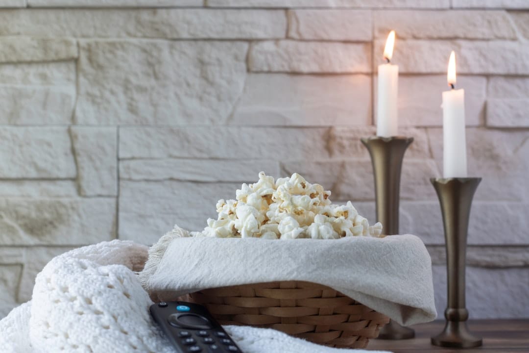Cozy evening at home with popcorn and candles perfect for enjoying THC edibles