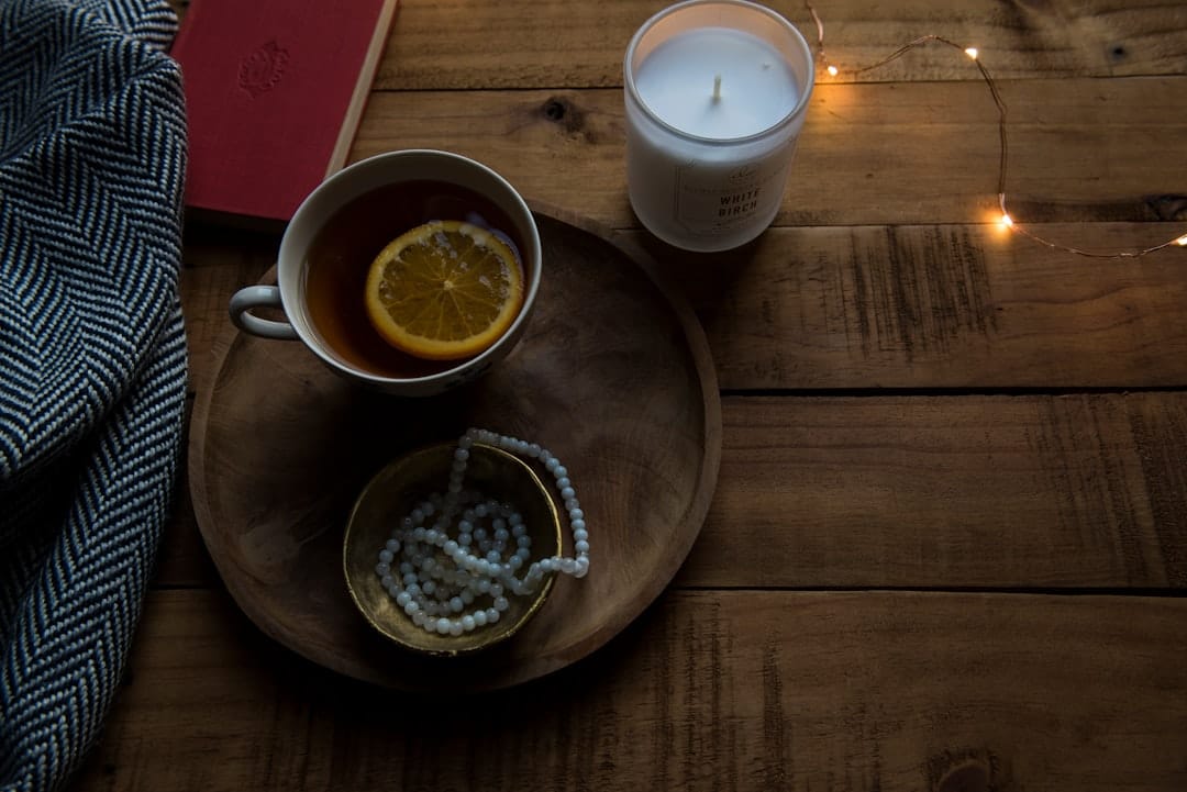 Cozy evening relaxation scene with ceramic mug and candle on wooden tray
