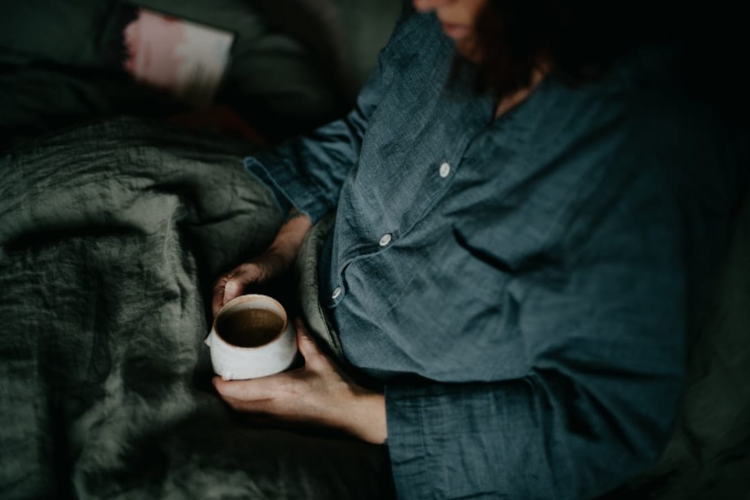 Cozy evening relaxation with a warm drink representing the calming effects of indica cannabis strains