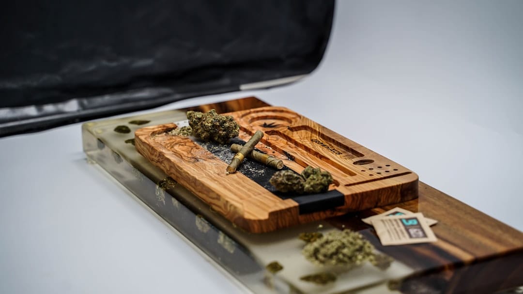 Cannabis and hash on a wooden board with rolling papers and smoking accessories