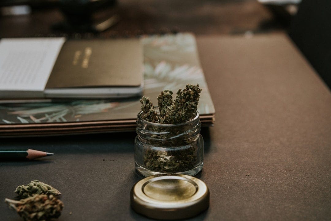Cannabis buds in a clear glass jar representing cheap ounces of weed available online in Canada