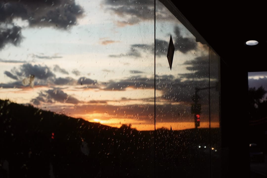 Sunset through rain-streaked window evoking a quiet Comox Valley evening at home