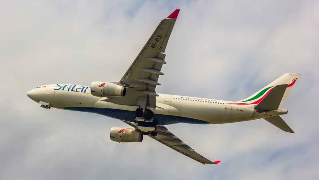 Passenger jet flying through cloudy skies, a nod to Gander International Airport