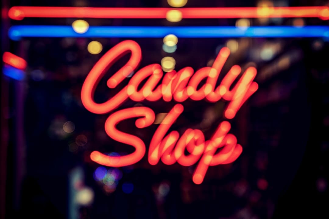 Pink candy shop neon sign symbolising Drip Edibles THC-infused real candies