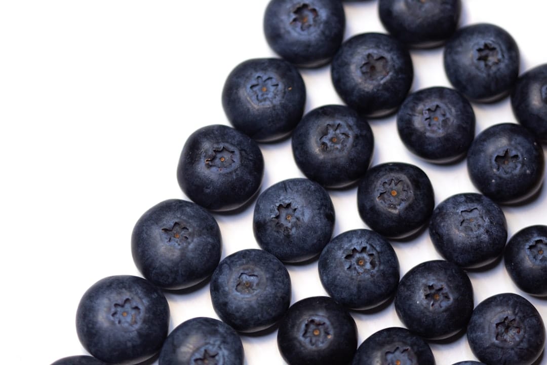 Fresh ripe blueberries piled on a white surface, representing the Blueberry parent in the Bluefin Tuna strain genetics