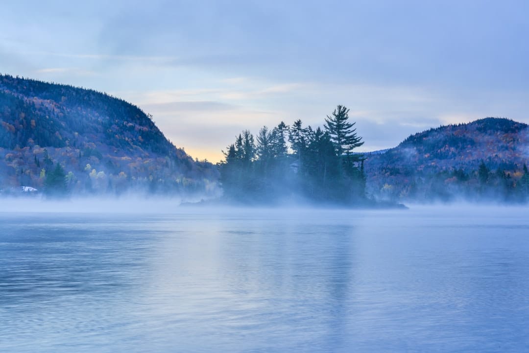 Mist hides a forested island on a lake in the Cantons-de-l'Est near Sherbrooke