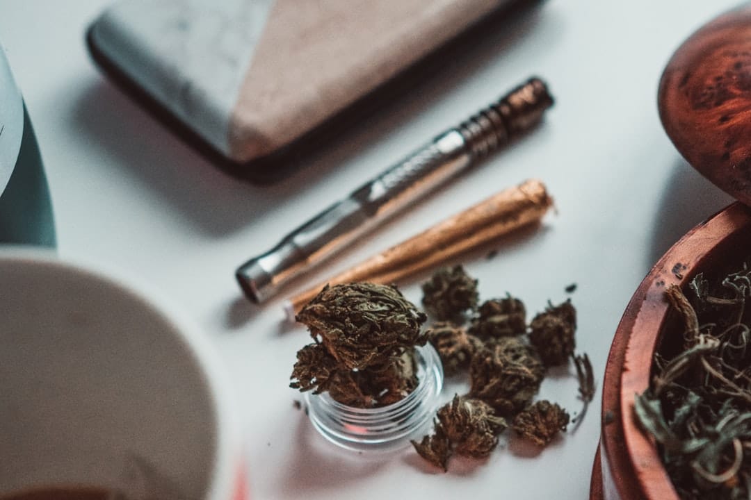 Ground cannabis flower in a wooden bowl beside a cup of coffee, a relaxed morning ritual