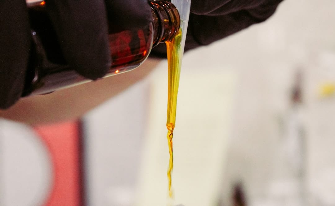Clear glass bottle with golden cannabis concentrate extract