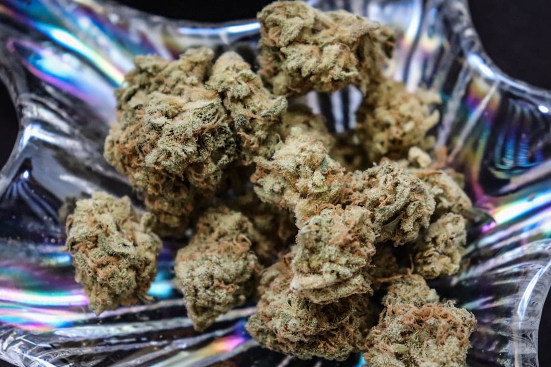 Cannabis buds covered in frosty trichomes on a metal tray showcasing AAAA craft quality