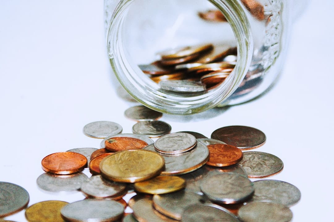 Glass jar filled with coins representing savings on value cannabis smalls