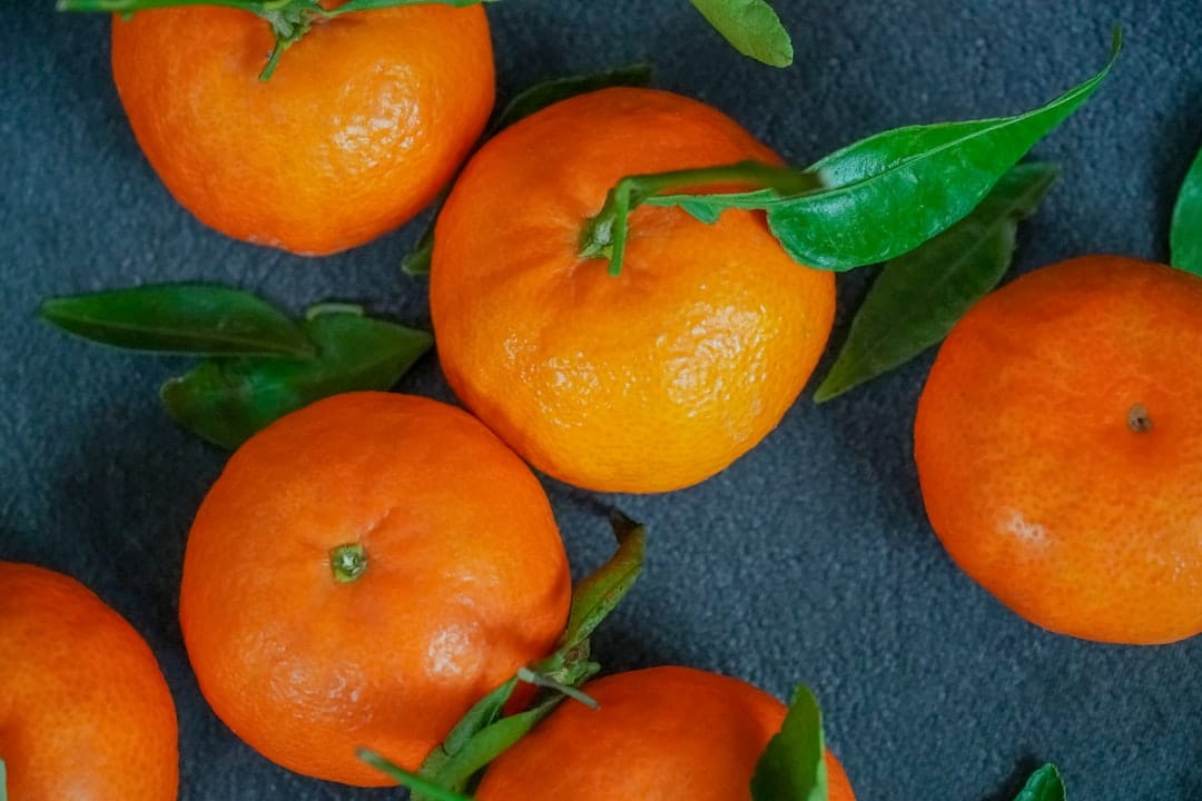 Fresh clementine oranges on neutral surface representing the dominant limonene terpene in Purple Mimosa strain
