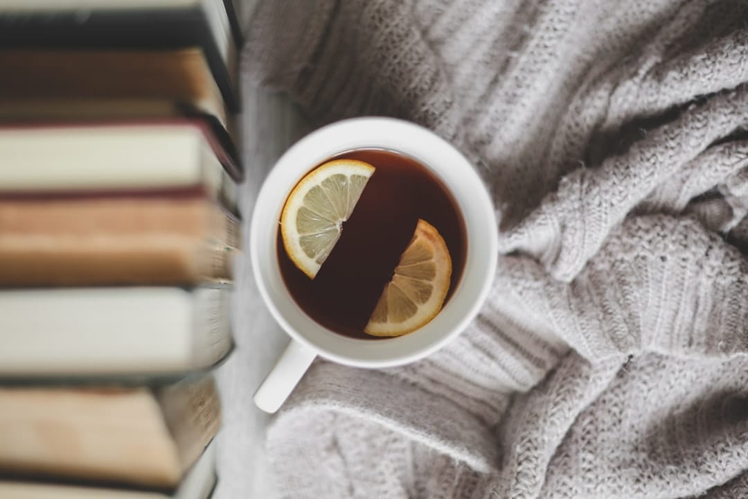 Cup of cannabis-infused herbal tea with lemon slices on a cozy blanket