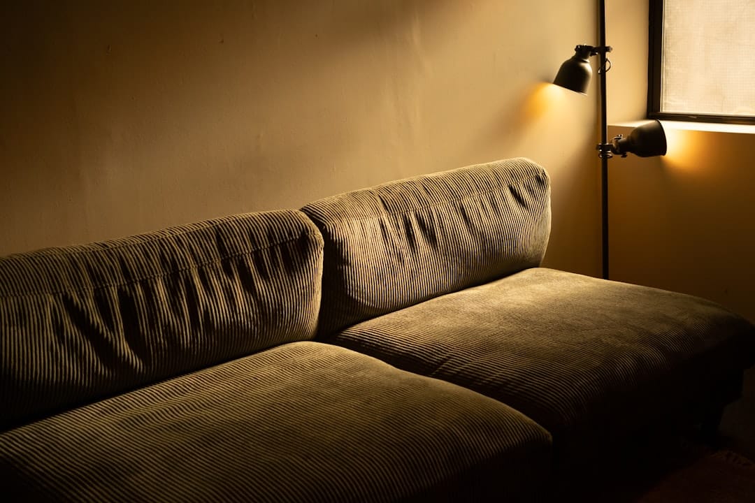Dimly lit cozy sofa with warm wall lamps creating a relaxing evening atmosphere
