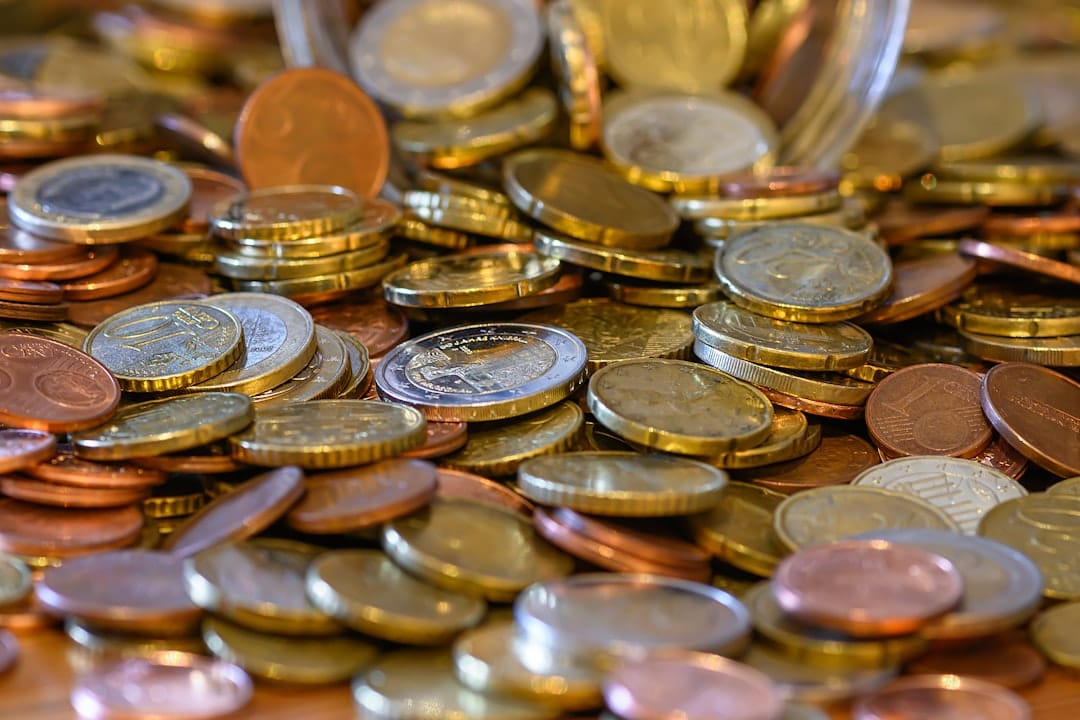 Coins stacked on wooden table showing cost savings of buying bulk THC edibles