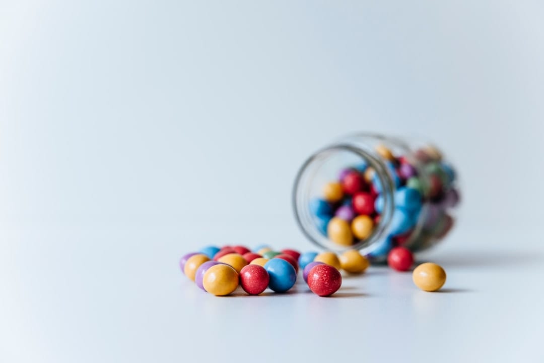 Colourful CBD and THC gummy candies in a glass jar for comparison