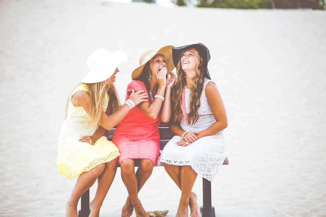 Three friends laughing together on a sunny day representing the social uplifting effects of sativa-dominant cannabis strains