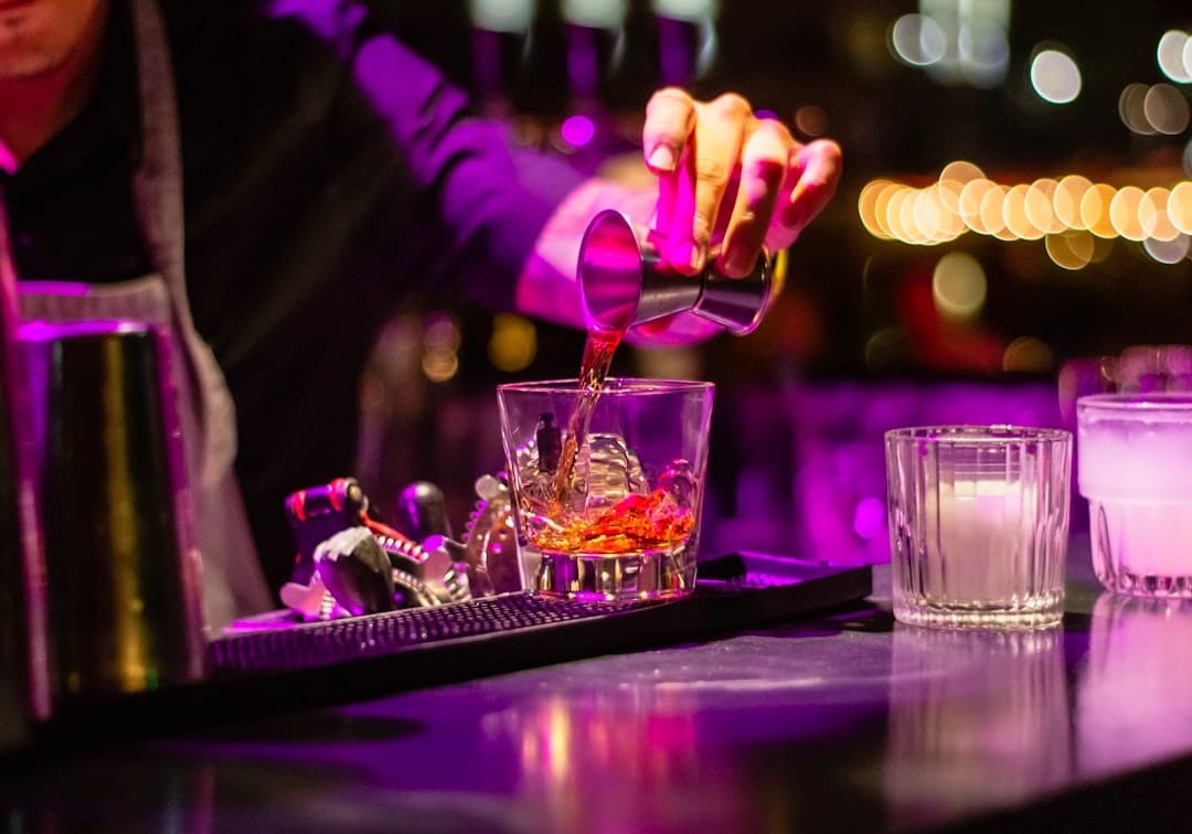 Person pouring liquid into a glass representing mixing CannaLean THC syrup into a beverage