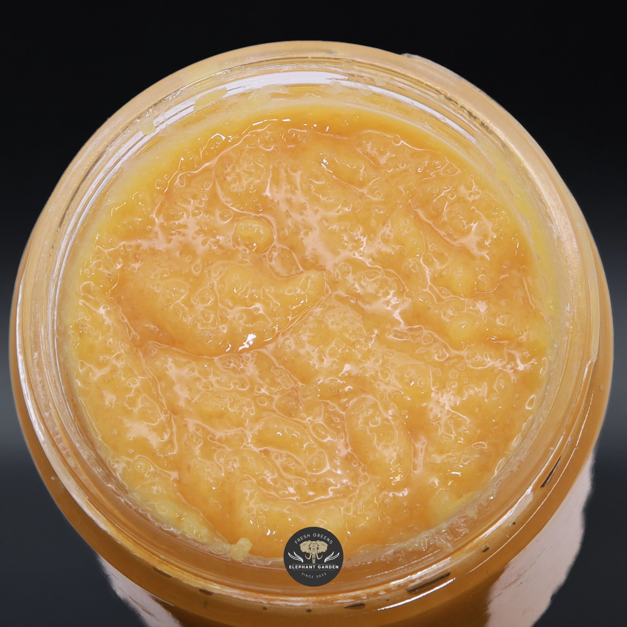 Cherry Thunder Fuck Live Resin, golden-orange sugary sauce in an open glass jar, top-down product photo