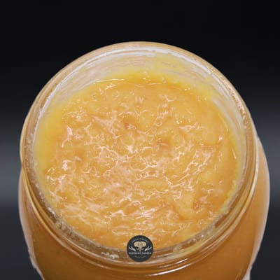 Purple Urkle live resin concentrate: golden, glossy sauce in an open glass jar, close-up product photo