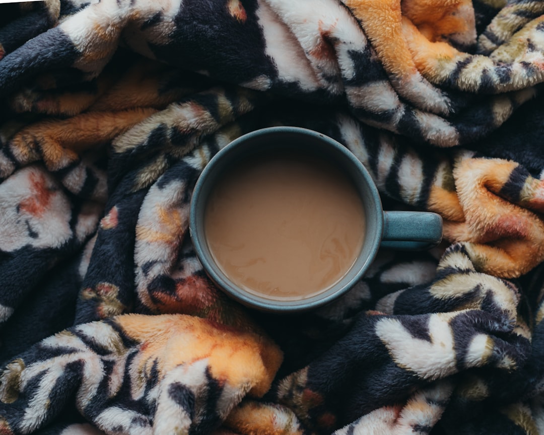 Cozy winter evening at home with a warm cup of coffee and soft blanket