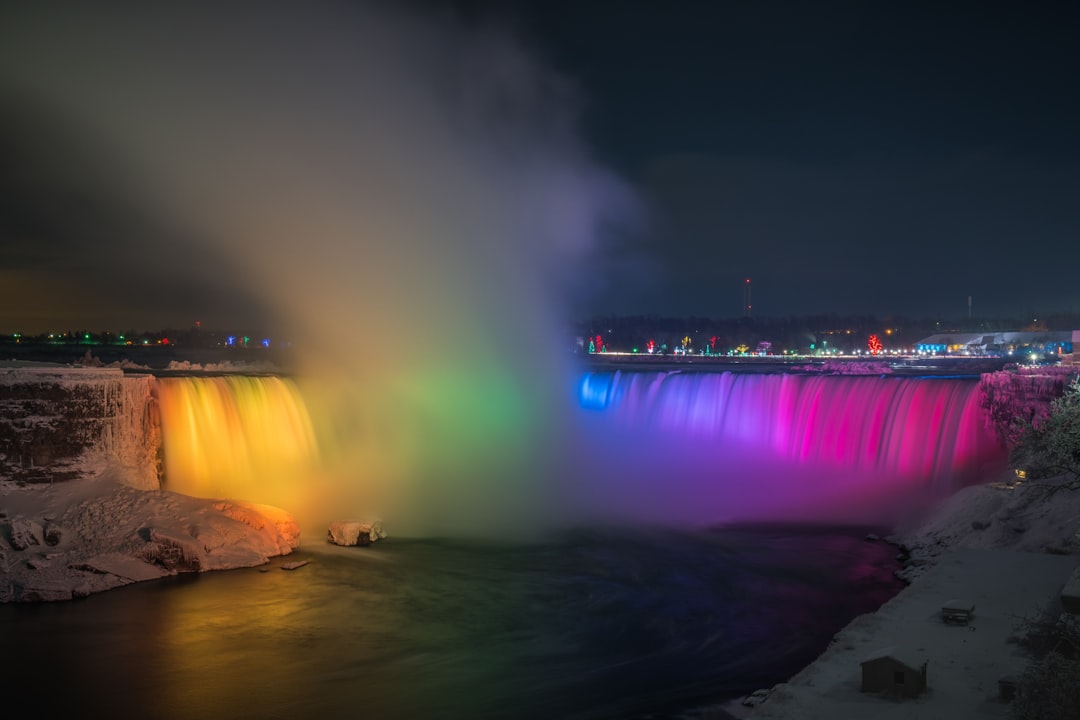 Niagara Falls lit up at night with city buildings and lights in Ontario