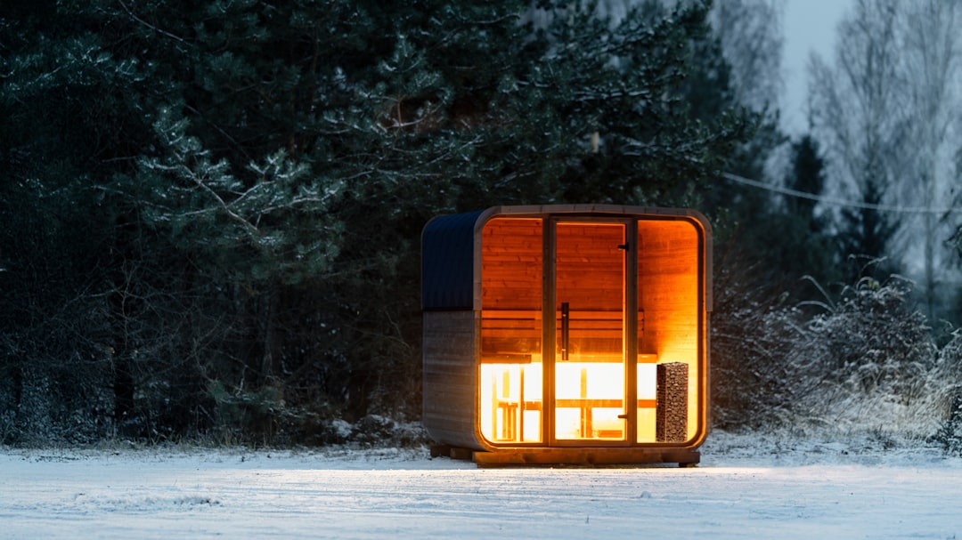 Warm cozy cabin illuminated in a snowy forest during winter dusk, perfect setting for relaxing with cannabis